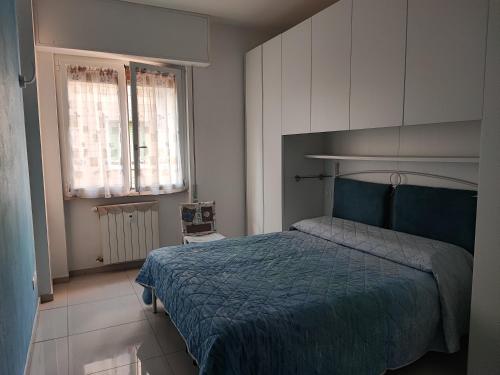 a bedroom with a blue bed and two windows at da Rosa in Finale Ligure