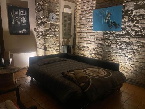a bed in a room with a brick wall at Habitació polivalent al centre de Manresa in Manresa