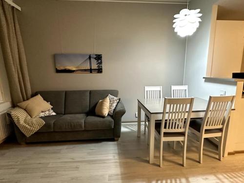 a living room with a couch and a table and chairs at Quality Apt in the City Center For 5 - BRAND NEW in Rovaniemi