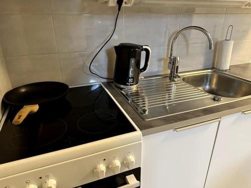 a kitchen with a sink and a coffee pot on the stove at Quality Apt in the City Center For 5 - BRAND NEW in Rovaniemi