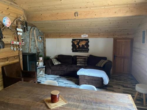 un salon avec un canapé et une table dans l'établissement CHALET L'Eyssinette Appartement 6 à 7 couchages, à Vars