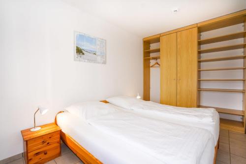 una piccola camera con letto e armadio in legno di Hanseat I Whg 45 a Grömitz