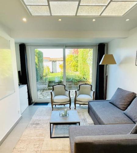 a living room with a couch and chairs and a table at Charmante petite maison flamande in Bondues