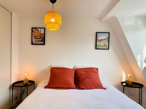 ein Schlafzimmer mit einem Bett mit drei Bildern an der Wand in der Unterkunft Charmante petite maison flamande in Bondues