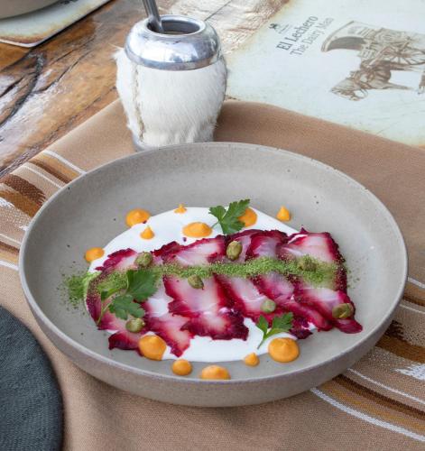 a plate of food on a table next to a book at Hotel Boutique La Yegua Loca in Punta Arenas