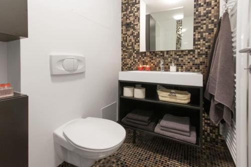 a bathroom with a white toilet and a sink at Gorgeous central flat with garage in Ljubljana