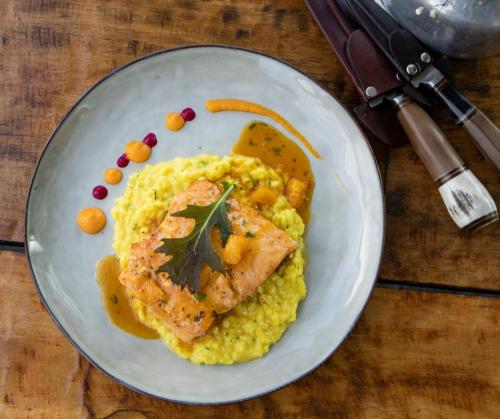 a plate of food with a piece of fish and mashed potatoes at Hotel Boutique La Yegua Loca in Punta Arenas