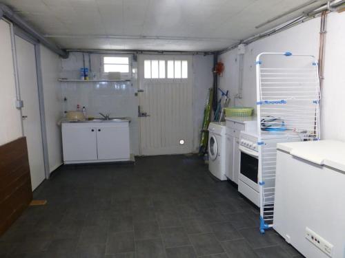 eine kleine Küche mit einem Herd und einer Waschmaschine in der Unterkunft Appartement 60 m2 indépendant au 1er étage d'une maison de ville in Lanester