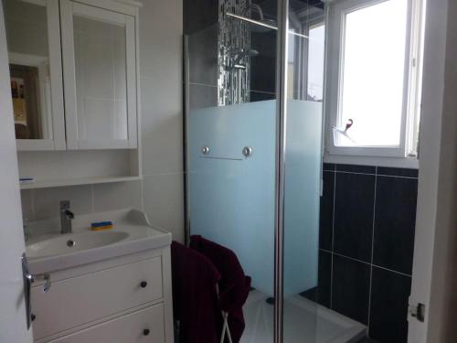 ein Bad mit einer Glasdusche und einem Waschbecken in der Unterkunft Appartement 60 m2 indépendant au 1er étage d'une maison de ville in Lanester