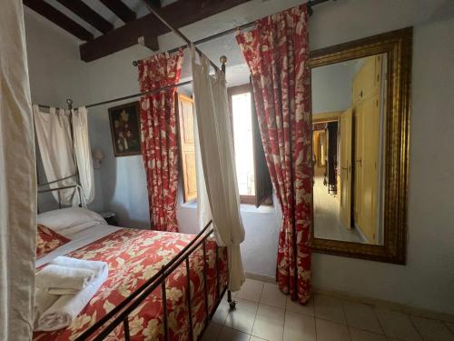 a bedroom with a bed with red curtains and a mirror at La Ventana in Ibiza Town