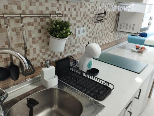 a kitchen sink with a dish rack on the counter at Estudio Torremolinos Centro by AVA Apartments Wifi y Smart TV in Torremolinos