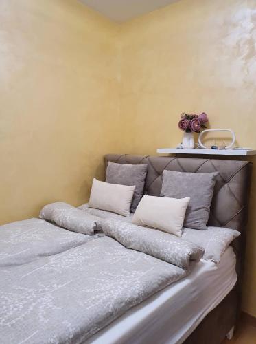a bed with pillows on it in a room at Centar view lux in Novi Sad