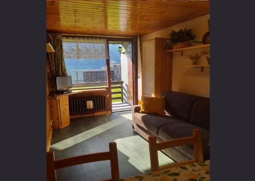 ein Wohnzimmer mit einem Sofa und einem großen Fenster in der Unterkunft Genepy Cervinia apartment Vda Vacanze in Vetta CIR 0252 in Breuil-Cervinia
