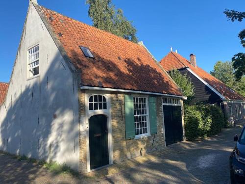 an old stone house with a red roof at Characteristic two bedroom home in Edam
