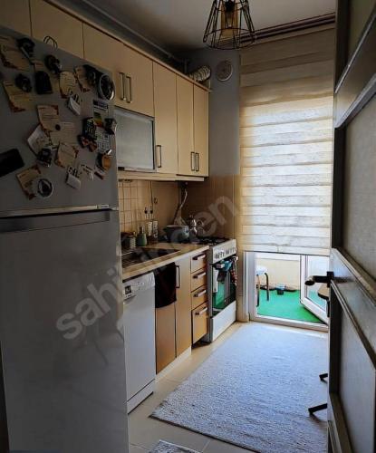 uma cozinha com electrodomésticos brancos e um piso verde em Istanbul em Basaksehir