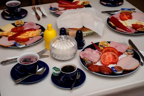 uma mesa branca com pratos de comida em Pensiune Roua 2 em Arad