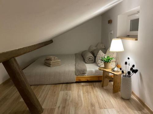 um quarto com uma cama e uma mesa com um candeeiro em Garden House em Roudnice nad Labem