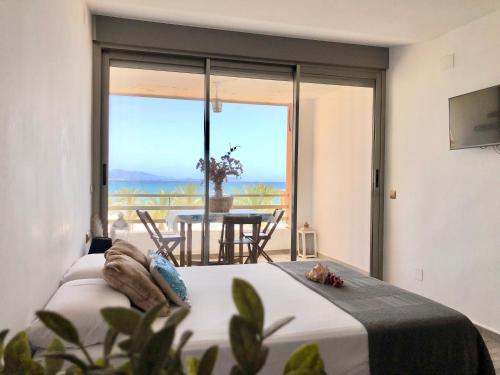 a bedroom with a bed and a view of the ocean at Estudio Playa Muchavista in El Campello