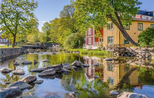 a river with rocks in front of a building at Nice Home In Norrtälje With Wifi in Norrtälje