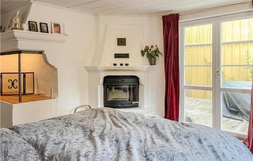 a bedroom with a fireplace and a bed at Nice Home In Norrtälje With Wifi in Norrtälje