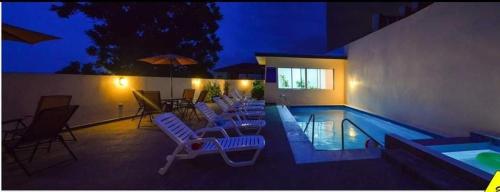 una piscina con tumbonas y una piscina en Hotel Palace Ejecutivo en San Pedro Sula