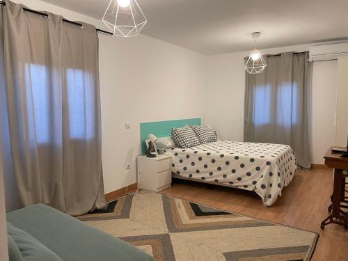 - une chambre avec 2 lits et une fenêtre avec des rideaux dans l'établissement Casa Tía María, à Navaluenga