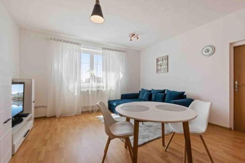 sala de estar con sofá azul y mesa en Modern & cozy flat near football & hockey arena en Trnávka