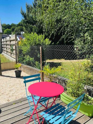two chairs and a red table and chairs on a deck at Logement indépendant,calme à 2 pas du centre ville in Lannion