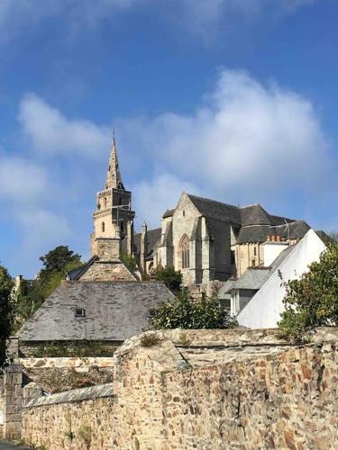 an old stone building with a church in the background at Logement indépendant,calme à 2 pas du centre ville in Lannion