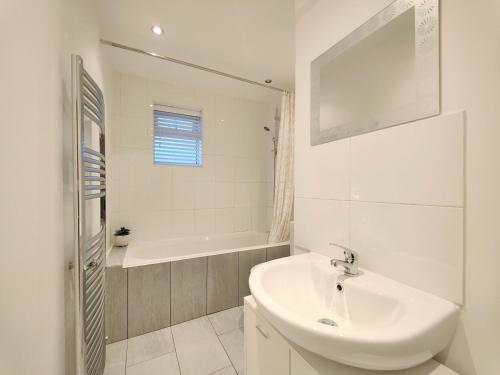 曼徹斯特的住宿－Stott House - Bright Spacious Townhouse 15 Minutes to Central Manchester With Free Parking，白色的浴室设有水槽和浴缸。