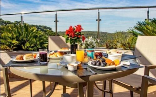 a table with breakfast food on a balcony at Golden Gramado Lagueto Resort in Gramado