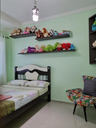 ein Schlafzimmer mit einem Bett, einem Stuhl und Regalen in der Unterkunft Casa Familiar em ótima Localização in Foz do Iguaçu