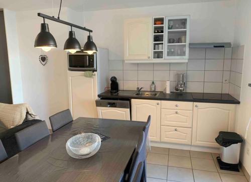 a kitchen with a table and a counter top at Magnifique T3 avec balcon vue montagne , plein centre et proche du lac in Gérardmer