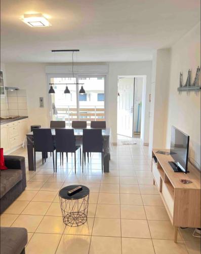 un salon avec une table et une salle à manger dans l'établissement Magnifique T3 avec balcon vue montagne , plein centre et proche du lac, à Gérardmer