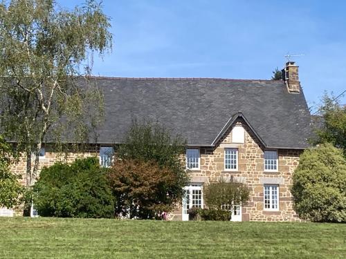 a large brick house with a black roof at « Le petit verger » in Hambye