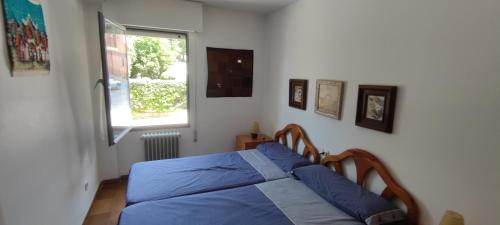 - une chambre avec un lit doté de draps bleus et une fenêtre dans l'établissement Triplex Vistas Candelario, à Candelario