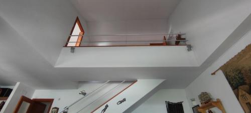 una escalera con una estantería de cristal en el techo en Triplex Vistas Candelario, en Candelario