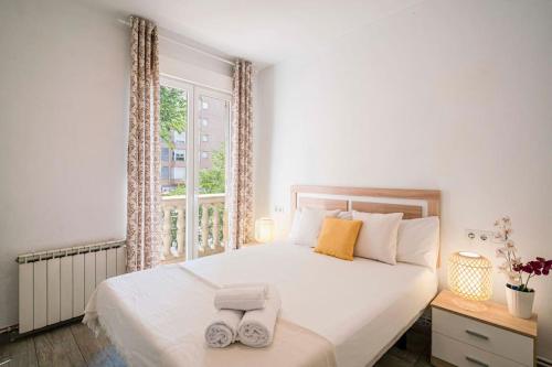 a bedroom with a large bed with two towels on it at Tranquilo apartamento en Principe Pío/Pza de España FLOR in Madrid