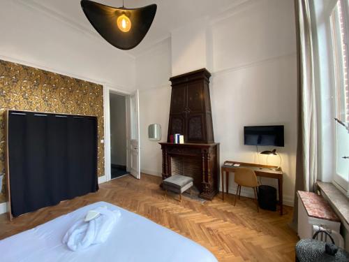 a bedroom with a bed and a desk and a television at Maison Mimerel Colodge in Roubaix