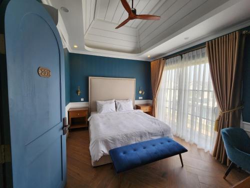 a blue bedroom with a bed and a ceiling fan at Florence Villa in Phan Thiet