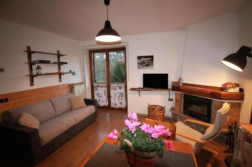 a living room with a couch and a fireplace at Cà Pizzo Scalino in Chiesa in Valmalenco