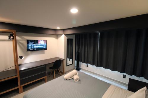 1 dormitorio con cama, escritorio y monitor en Casa Romita, en Ciudad de México