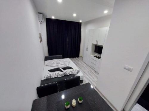 a small room with a bed and a table in it at Apartman Fortuna in Banja Luka