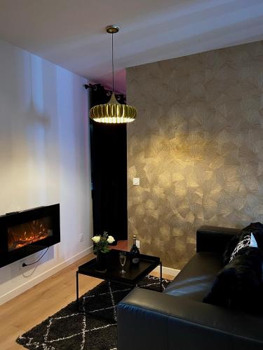 un salon avec un canapé et une cheminée dans l'établissement La Belle Nuit suite Nuit Étoilée, à Saint-Gilles