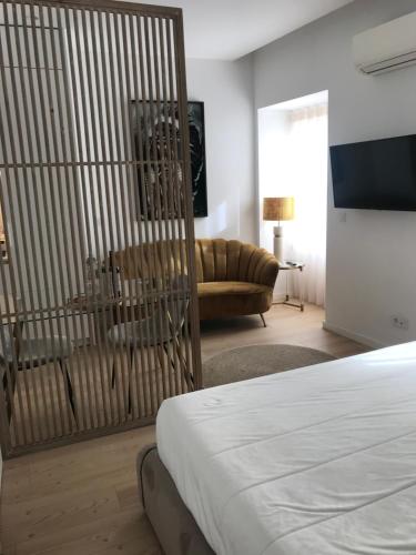 Cette chambre comprend un lit, un canapé et une télévision. dans l'établissement Aveiro Garden's Home, à Aveiro