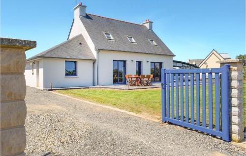 une maison avec une clôture bleue devant elle dans l'établissement Amazing Home In Plouézec With Wifi, à Plouézec