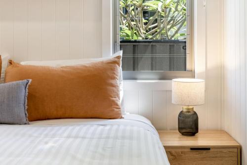 a bed with a pillow and a lamp on a table at Park Lane - 4B Wattle Street in Evans Head