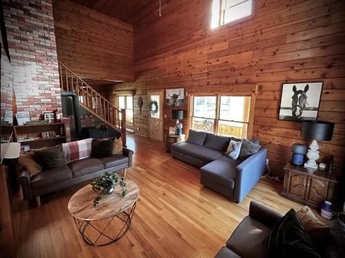 a living room with couches and a table at Cabin close to Lake Willoughby and ski areas in Barton