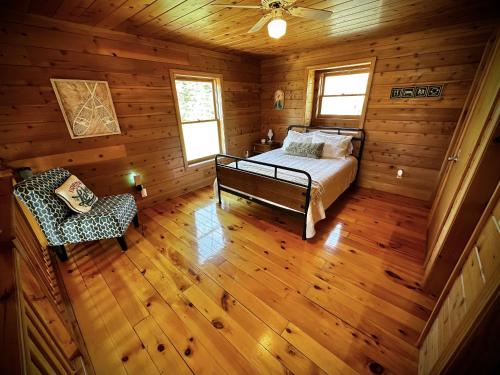 1 dormitorio con 1 cama y 1 silla en una cabaña en Cabin close to Lake Willoughby and ski areas, en Barton