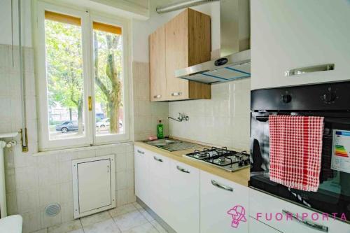 帕爾馬的住宿－Residence Dacci，厨房配有白色橱柜和炉灶烤箱。